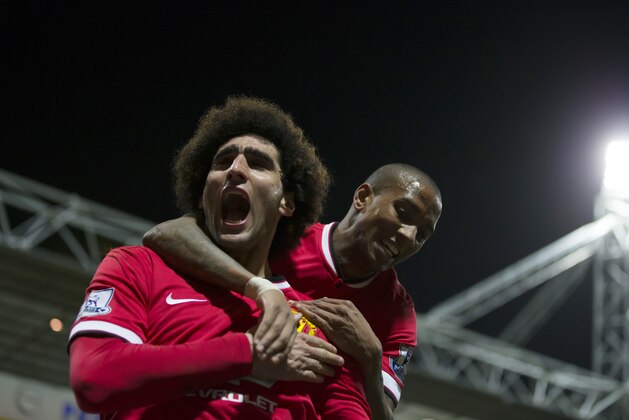 Manchester United's Marouane Fellaini, left, celebrates with teammate Ashley Young after scoring during the English FA Cup Fifth Round soccer match between Preston and Manchester United at Deepdale Stadium in Preston, England, Monday Feb. 16, 2015.  (AP Photo/Jon Super)