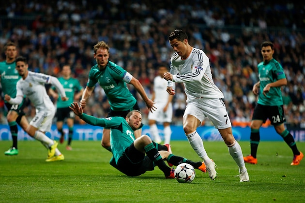 MADRID, SPAIN - MARCH 18:  Cristiano Ronaldo of Real Madrid is tackled by Tim Hoogland of Schalke during the UEFA Champions League Round of 16, second leg match between Real Madrid and FC Schalke 04 at Estadio Santiago Bernabeu on March 18, 2014 in Madrid, Spain.  (Photo by Gonzalo Arroyo Moreno/Getty Images)