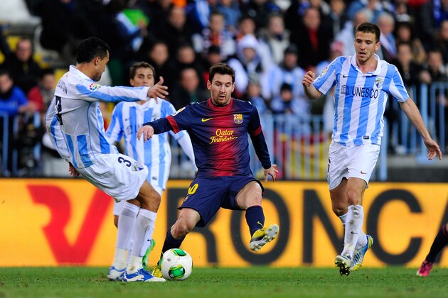 MALAGA, SPAIN - JANUARY 24:  Lionel Messi of FC Barcelona duels for the ball with Welligton Robson (L) and Ignacio Camacho of Malaga CF during the Copa del Rey Quarter Final 2nd leg match between Malaga CF and FC Barcelona at La Rosaleda Stadium on January 24, 2013 in Malaga, Spain.  (Photo by David Ramos/Getty Images)