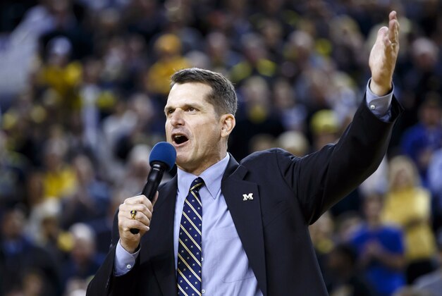 Dec 30, 2014; Ann Arbor, MI, USA; Michigan Wolverines head football coach Jim Harbaugh address the crowd during halftime of the game against the Illinois Fighting Illini at Crisler Center. Mandatory Credit: Rick Osentoski-USA TODAY Sports