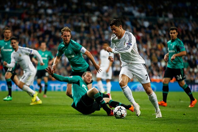 MADRID, SPAIN - MARCH 18:  Cristiano Ronaldo of Real Madrid is tackled by Tim Hoogland of Schalke during the UEFA Champions League Round of 16, second leg match between Real Madrid and FC Schalke 04 at Estadio Santiago Bernabeu on March 18, 2014 in Madrid, Spain.  (Photo by Gonzalo Arroyo Moreno/Getty Images)