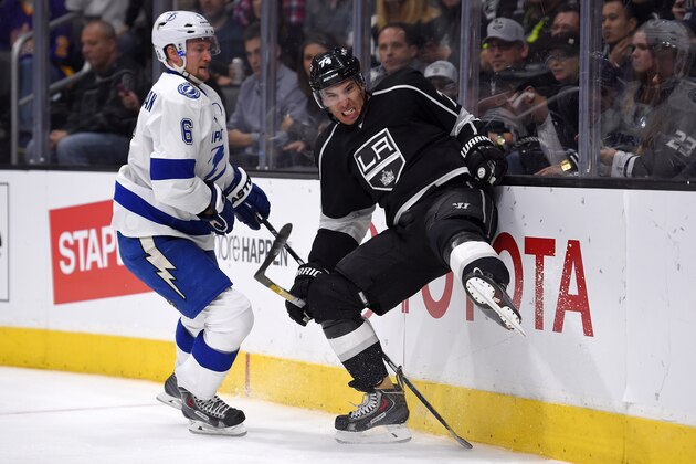 Los Angeles Kings left wing Dwight King, right, runs into the boards under pressure from Tampa Bay Lightning defenseman Anton Stralman, of Sweden, during the second period of an NHL hockey game, Monday, Feb. 16, 2015, in Los Angeles. (AP Photo/Mark J. Terrill)