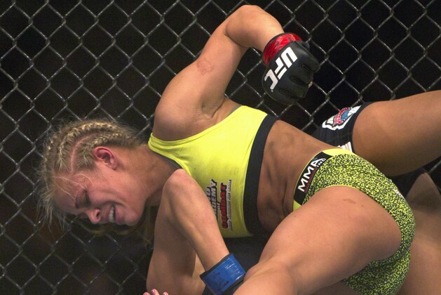 Paige Vanzant, top, throws a punch against Kailin Curren in a women's strawweight mixed martial arts bout during the UFC Fight Night at the Frank Erwin Center in Austin, Texas, Saturday, Nov. 22, 2014. (AP Photo/Michael Thomas)