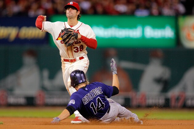 St. Louis Cardinals second baseman Pete Kozma, top, turns a double play over Colorado Rockies' Josh Rutledge to end the top of the seventh inning of a baseball game Saturday, Sept. 13, 2014, in St. Louis. (AP Photo/Scott Kane)