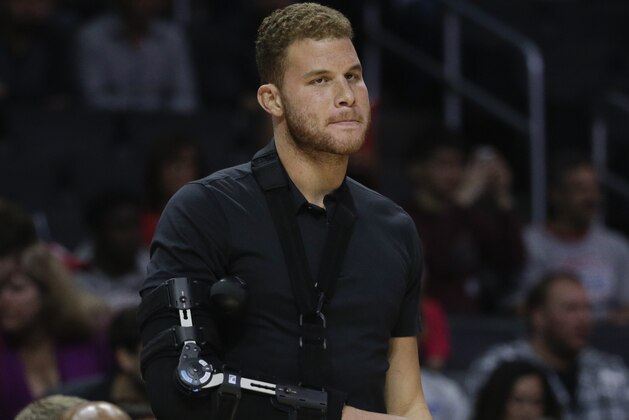 Los Angeles Clippers' Blake Griffin, who had surgery Monday to remove a staph infection from his right elbow, watches from the bench during an NBA basketball game against the Houston Rockets, Wednesday, Feb. 11, 2015, in Los Angeles. (AP Photo/Jae C. Hong)