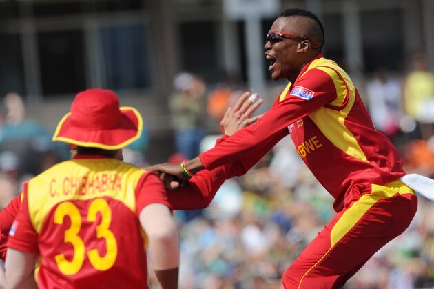 Zimbabwe Tafadzwa Kamungozi jumps up toward teammates after taking the wicket of South Africa's AB de Villiers for 25 runs during their Cricket World Cup pool B match at Hamilton, New Zealand, Sunday, Feb. 15, 2015. (AP Photo/Ross Setford)