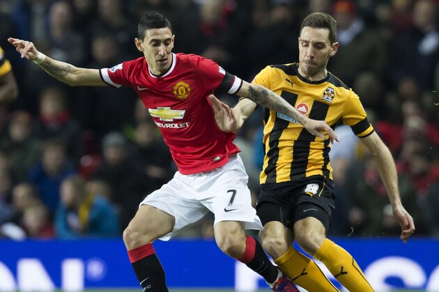 Manchester United's Angel Di Maria, left, fights for the ball against  Cambridge's Tom Champion during their English FA Cup fourth-round replay soccer match between Manchester United and Cambridge at Old Trafford Stadium, Manchester, England, Tuesday Feb. 3, 2015. (AP Photo/Jon Super)