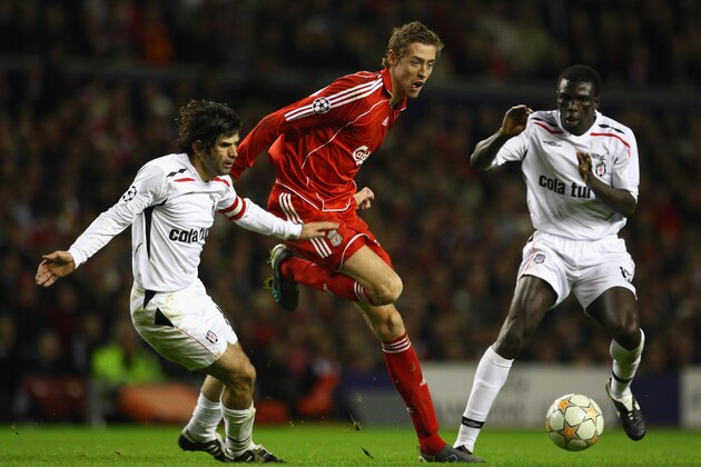 LIVERPOOL, UNITED KINGDOM - NOVEMBER 06:  Peter Crouch of Liverpool surges away from Lamine Diatta and Ibrahim Uzulmez (L) of Besiktas during the UEFA Champions League Group A match between Liverpool and Besiktas at Anfield on November 6, 2007 in Liverpool, England. (Photo by Laurence Griffiths/Getty Images)