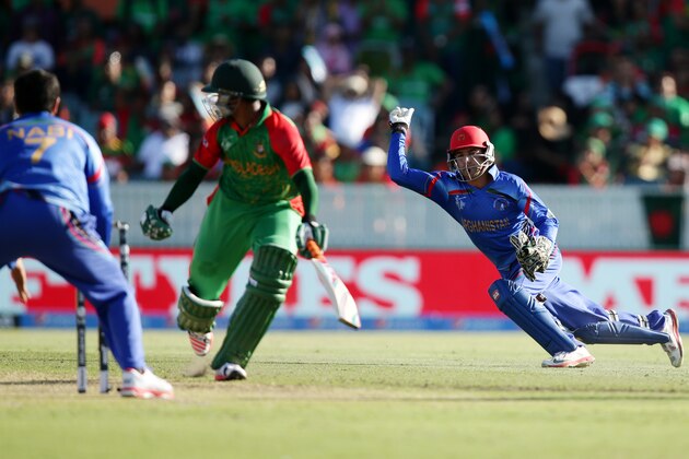 Afghanistan’s wicketkeeper  Zazai Afsar, right, throws the ball at the stumps as he attempts to run out Bangladesh’s Al Hasan Shakib during their Cricket World Cup Pool A match in Canberra, Australia, Wednesday, Feb. 18, 2015. (AP Photo/Rob Griffith)
