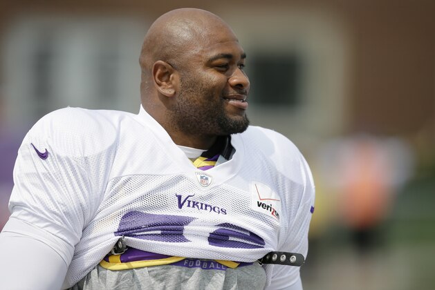 FILE - This July 30, 2014, file photo, shows Minnesota Vikings defensive tackle Tom Johnson walking to the field before an NFL football training camp practice in Mankato, Minn. A police report shows Minneapolis officers used a chemical spray and a stun gun on Vikings' Tom Johnson after he refused to leave a downtown club. Johnson, who is listed at 6-foot-3 and 288 pounds, was arrested early Sunday, Oct. 5, 2014,  after security officials and police repeatedly told him to leave Seven steakhouse in Minneapolis. He was charged with misdemeanor counts of trespassing and disorderly conduct.  (AP Photo/Charlie Neibergall, File)
