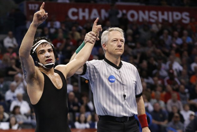 Iowa's Tony Ramos, left, celebrates after defeating Wisconsin's Tyler Graff in the 133-pound match in the finals of the NCAA Division I wrestling championships in Oklahoma City, Saturday, March 22, 2014. (AP Photo/Sue Ogrocki)