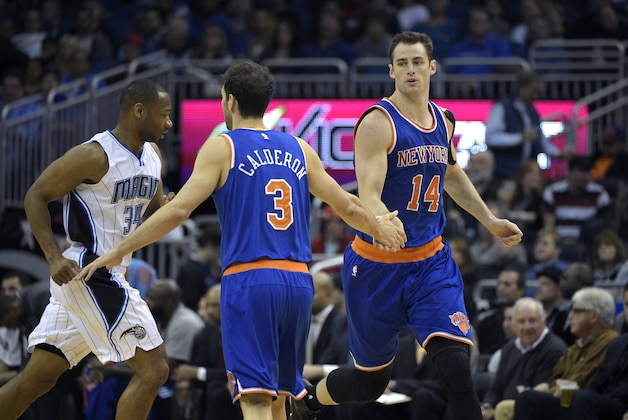 New York Knicks forward Jason Smith (14) is congratulated by guard Jose Calderon (3) after scoring a basket in front of Orlando Magic guard Willie Green (34) during the first half of an NBA basketball game in Orlando, Fla., Wednesday, Feb. 11, 2015.(AP Photo/Phelan M. Ebenhack)