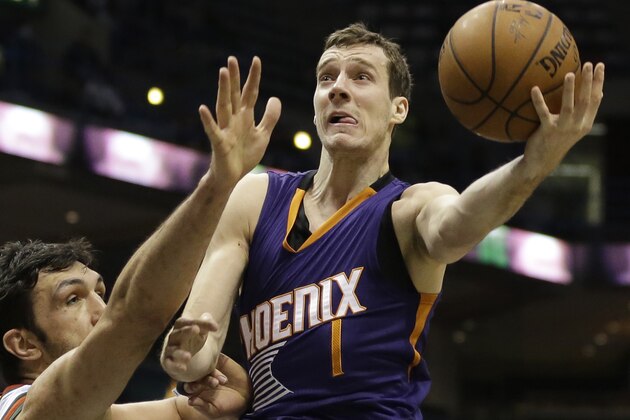 Phoenix Suns' Goran Dragic attempts a layup over Milwaukee Bucks' Zaza Pachulia during an NBA basketball game Tuesday, Jan. 6, 2015, in Milwaukee. (AP Photo/Aaron Gash)