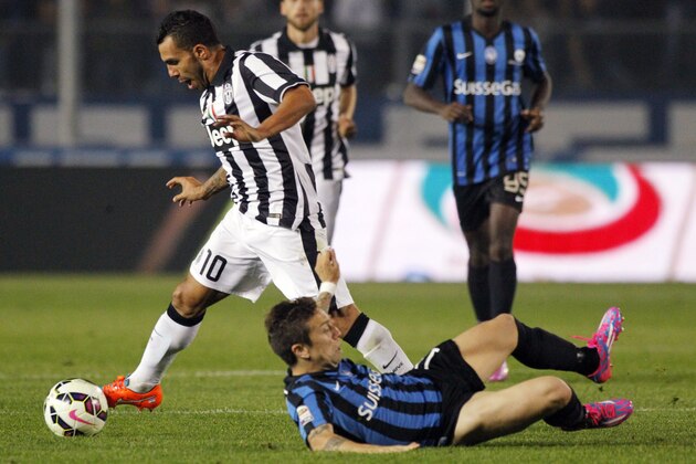 Juventus forward Carlos Tevez, left, of Argentina dribbles past Atalanta's Alejandro Dario Gomez during a Serie A soccer match in Bergamo, Italy, Saturday, Sept. 27, 2014. (AP Photo/Felice Calabro')