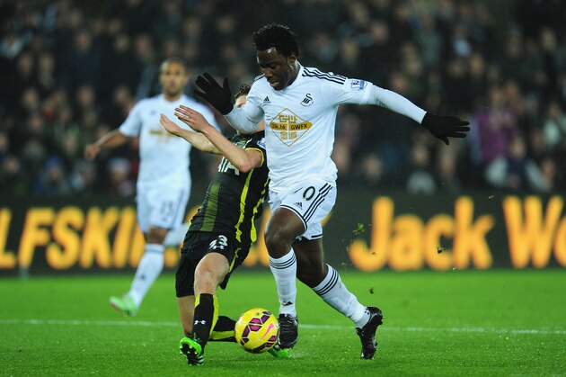 SWANSEA, WALES - DECEMBER 14:  Spurs player Ben Davies (l) challenges Swansea player Wilfried Bony during the Barclays Premier League match between Swansea City and Tottenham Hotspur at Liberty Stadium on December 14, 2014 in Swansea, Wales.  (Photo by Stu Forster/Getty Images)