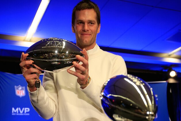 PHOENIX, AZ - FEBRUARY 02:  (L-R) Tom Brady of the New England Patriots holds the Super Bowl XLIX MVP trophy during a Chevrolet Super Bowl XLIX MVP press conference folowing the Patriots Super Bowl win over the Seattle Seahawks on February 2, 2015 in Phoenix, Arizona.  (Photo by Jamie Squire/Getty Images)