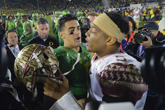 FILE - In this Jan. 1, 2015, file photo, Oregon quarterback Marcus Mariota, center left, greets Florida State quarterback Jameis Winston after Oregon's win in the Rose Bowl NCAA college football playoff semifinal in Pasadena, Calif. Heisman Trophy winners Jameis Winston and Marcus Mariota reunite at the NFL combine, their first meeting since Oregon routed Florida State in the Rose Bowl. (AP Photo/Mark J. Terrill, File)