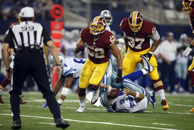Washington Redskins' Keenan Robinson (52) celebrates sacking Dallas Cowboys' Tony Romo (9) as the Redskins' Jason Hatcher (97) stands over Romo during the second half of an NFL football game, Monday, Oct. 27, 2014, in Arlington, Texas. Romo was injured on the play. (AP Photo/Tim Sharp)