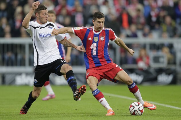Paderborn's Christian Strohdiek, left, and Bayern's Robert Lewandowski from Poland challenge for the ball during the German first division Bundesliga soccer match between FC Bayern and SC Paderborn 07 in the Allianz Arena in Munich, Germany, on Tuesday, Sept. 23, 2014. (AP Photo/Matthias Schrader)