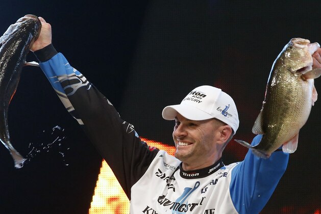 Randy Howell, Springville, Ala., holds up two bass at a weigh-in, Sunday Feb. 23, 2014 in Birmingham, Ala. that helped him win the Bassmaster Classic on Lake Guntersville. (AP Photo/Hal Yeager)