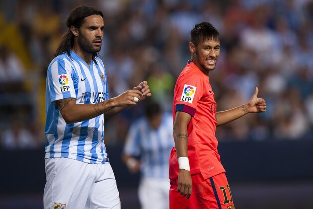 FC Barcelona's Neymar da Silva from Brazil, right, gives a thumbs up with Malaga's Sergio Sanchez, left, during a Spanish La Liga soccer match between Malaga and Barcelona at La Rosaleda stadium in Malaga, Spain, Wednesday, Sept. 24, 2014. (AP Photo/Daniel Tejedor)