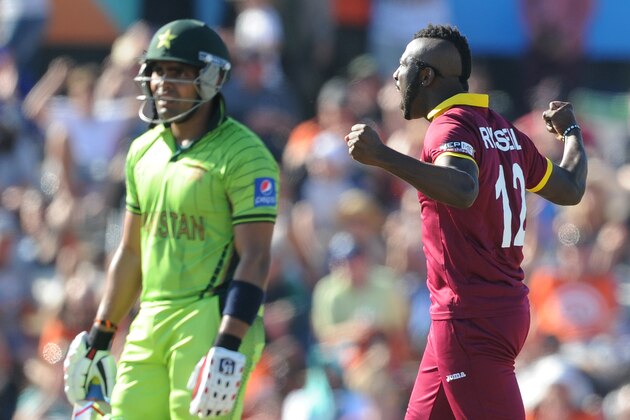 West Indies bowler Andre Russell, right, celebrates after dismissing Pakistan's Umar Akmal, left, during their Cricket World Cup match in Christchurch, New Zealand, Saturday, Feb. 21, 2015. (AP Photo/Ross Setford)