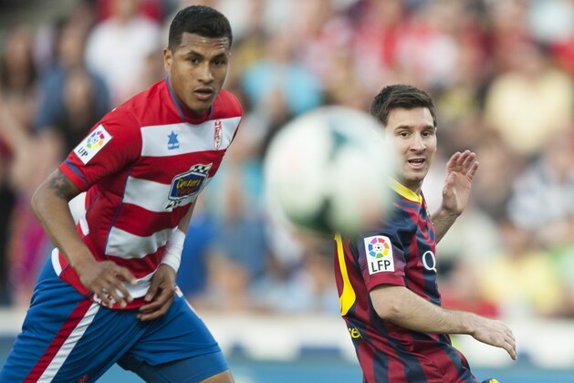 Barcelona's Lionel Messi from Argentina, right, in action with Granada's Jeison Murillo from Colombia during a Spanish La Liga soccer match between FC Granada and FC Barcelona at Los Carmenes stadium in Granada, Spain, Saturday, April 12, 2014. (AP Photo/Daniel Tejedor)