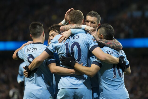 Manchester City's Edin Dzeko, centre left, celebrates with teammates after scoring against the English Premier League soccer match between Manchester City and Newcastle at the Etihad Stadium, Manchester, England, Saturday Feb. 21, 2015. (AP Photo/Jon Super)