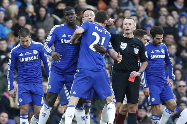 Chelsea's Nemanja Matic, centre back to camera, is held by teammates as he tries to reach referee Martin Atkinson, after he was sent off with a red card, during an English Premier League soccer match against Burnley at the Stamford Bridge ground in London, Saturday, Feb. 21, 2015. The match ended 1-1 draw. (AP Photo/Lefteris Pitarakis)
