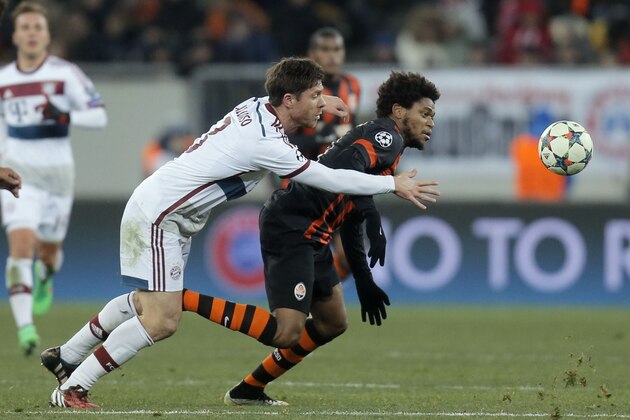 Bayern's Xabi Alonso, left, and Shakhtar's Luiz Adriano struggle for the ball during the Champions League round of 16 first leg soccer match between Shakhtar Donetsk and Bayern Munich on Tuesday, Feb. 17, 2015 in Lviv, Ukraine. (AP Photo/Efrem Lukatsky)