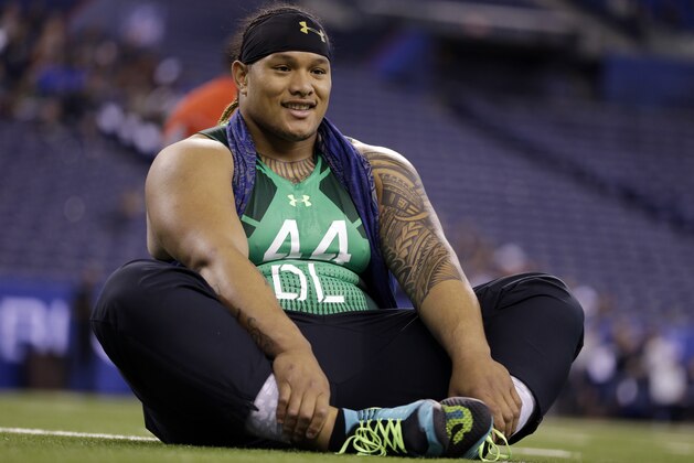Washington defensive lineman Danny Shelton stretches before drills at the NFL football scouting combine in Indianapolis, Sunday, Feb. 22, 2015. (AP Photo/Julio Cortez)