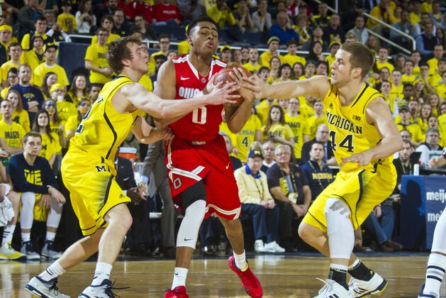 Ohio State guard D'Angelo Russell (0) tries to keep the ball while challenged by Michigan guard Spike Albrecht, left, and forward Max Bielfeldt, right, in the first half of an NCAA college basketball game at Crisler Center in Ann Arbor, Mich., Sunday, Feb. 22, 2015. (AP Photo/Tony Ding)