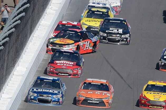 Tony Stewart (14) hits the wall with Ryan Blaney (21) on the front stretch during the Daytona 500 NASCAR Sprint Cup series auto race at Daytona International Speedway, Sunday, Feb. 22, 2015, in Daytona Beach, Fla. (AP Photo/Phelan M. Ebenhack)