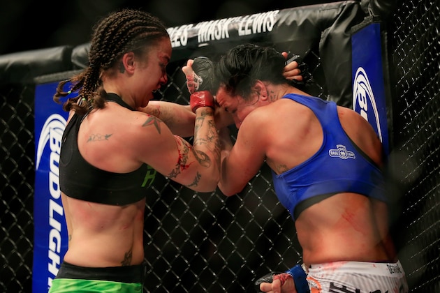 LAS VEGAS, NV - DECEMBER 06:  Raquel Pennington (green shorts) and Ashlee Evans-Smith (white shorts) grapple against the cage in their fight during the UFC 181 event at the Mandalay Bay Events Center on December 6, 2014 in Las Vegas, Nevada.  (Photo by Alex Trautwig/Getty Images)