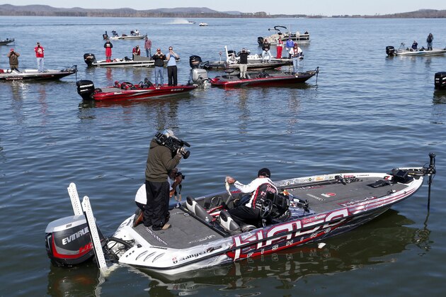 Randall Tharp, Port Saint Joe, Fla., holds up a bass for spectators following him on the second day of the Bassmaster Classic, Saturday, Feb. 22, 2014, in Guntersville, Ala. Tharp was bumped from first to second by 1 ounce by Edwin Evers, Talala, Okla. The field will be cut to the top 25 anglers for the final day of competition. (AP Photo/Hal Yeager)