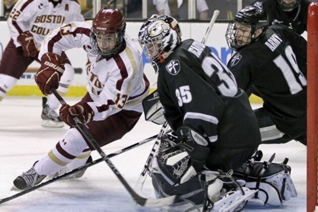 Boston College's Johnny Gaudreau (13) tries to score against Providence College goaltender Alex Beaudry (35) as Derek Army (19) helps to defend the net in the second period of an NCAA college hockey game in the semifinals of the Hockey East tournament in Boston, Friday, March 16, 2012. (AP Photo/Elise Amendola)