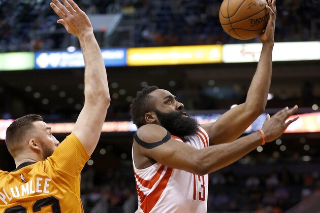 Houston Rockets' James Harden (13) drives past Phoenix Suns' Miles Plumlee, left, for a score during the first half of an NBA basketball game Friday, Jan. 23, 2015, in Phoenix. (AP Photo/Ross D. Franklin)