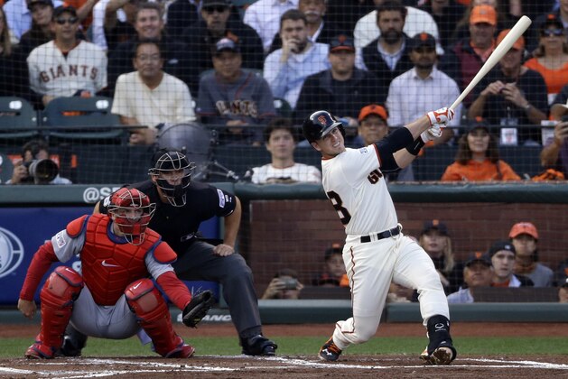 San Francisco Giants' Buster Posey watches his RBI sacrifice fly against the St. Louis Cardinals during the first inning of Game 4 of the National League baseball championship series Wednesday, Oct. 15, 2014, in San Francisco. (AP Photo/Jeff Chiu)