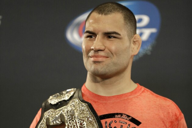 UFC heavyweight champion Cain Velasquez poses with his championship belt following a media availability Thursday, Oct. 17, 2013, in Houston. Velasquez will face former UFC heavyweight champion Junior Dos Santos in a rematch in Houston Saturday. He beat Santos in a five-round decision in December to regain the title after Santos won in a knockout in the first meeting in 2011. (AP Photo/Pat Sullivan)