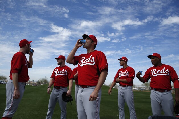 Cincinnati Reds' player Matt Magill, center, drinks water with other players during pitchers and catchers spring training practice Thursday, Feb. 19, 2015, in Goodyear, Ariz. (AP Photo/John Locher)