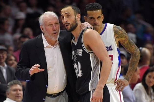 San Antonio Spurs head coach Gregg Popovich, left, talks with guard Manu Ginobili, center, of Argentina, as Los Angeles Clippers forward Matt Barnes listens in during the second half of an NBA basketball game, Thursday, Feb. 19, 2015, in Los Angeles. The Clippers won 119-115. (AP Photo/Mark J. Terrill)