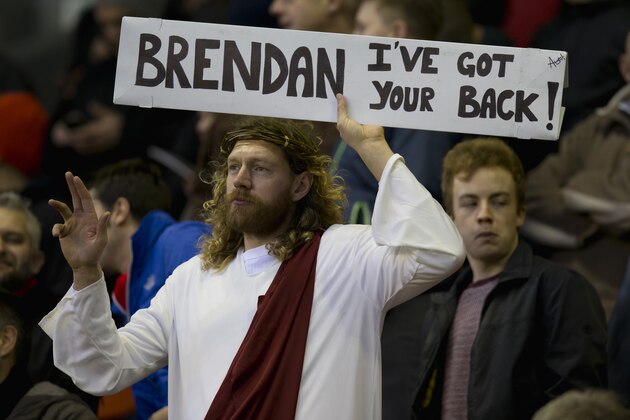 A Liverpool supporter dressed in the stereotypical image of Jesus holds up a sign supporting manager Brendan Rodgers before the team's English Premier League soccer match against Arsenal at Anfield Stadium, Liverpool, England, Sunday Dec. 21, 2014. (AP Photo/Jon Super)