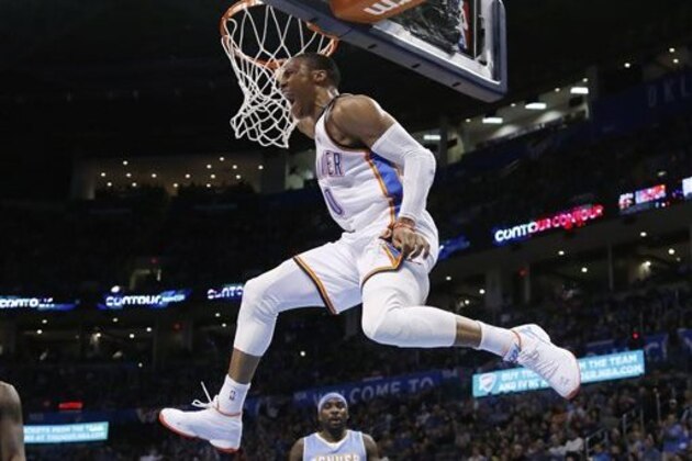 CORRECTS FINAL SCORE TO 119-94 - Oklahoma City Thunder guard Russell Westbrook (0) hangs from the basket in front of Denver Nuggets guard Ty Lawson (3) following a dunk in the third quarter of an NBA basketball game in Oklahoma City, Sunday, Feb. 22, 2015. Oklahoma City won 119-94. (AP Photo/Sue Ogrocki)
