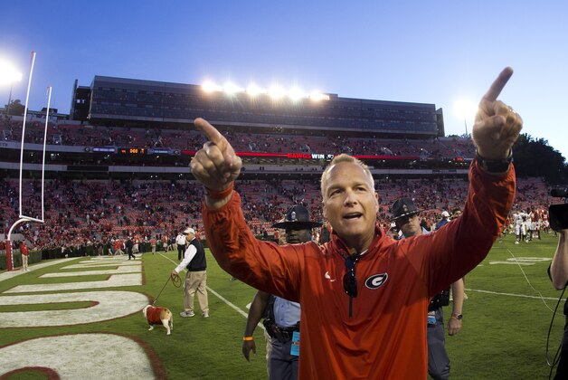 FILE - In this Oct. 4, 2014, file photo, Georgia head coach Mark Richt gestures towards the band after defeating Vanderbilt  44-17 in an NCAA college football game in Athens, Ga. Georgia football coach Richt has received a two-year contract extension that ties him to the Bulldogs through 2019 and increases his salary to $4 million a year. The school's executive committee approved the new contract Wednesday, Jan. 21, 2015, boosting Richt from $3.2 million a year. (AP Photo/John Bazemore, File)