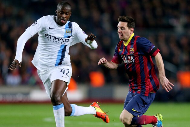 BARCELONA, SPAIN - MARCH 12:  Yaya Toure of Manchester City and Lionel Messi of Barcelona compete for the ball during the UEFA Champions League Round of 16, second leg match between FC Barcelona and Manchester City  at Camp Nou on March 12, 2014 in Barcelona, Spain.  (Photo by Alex Livesey/Getty Images)