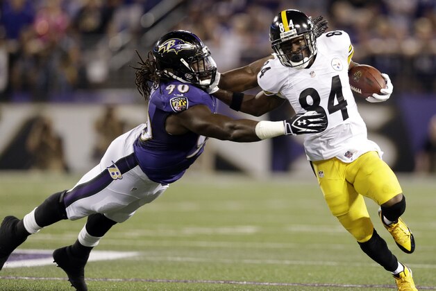 Baltimore Ravens linebacker Pernell McPhee (90) is pushed away by Pittsburgh Steelers wide receiver Antonio Brown (84) during the first half of an NFL football game Thursday, Sept. 11, 2014, in Baltimore. (AP Photo/Patrick Semansky)