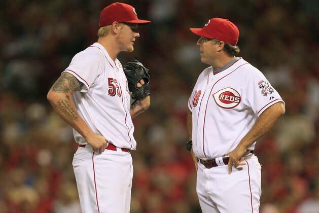 Cincinnati Reds starting pitcher Mat Latos talks with pitching coach Bryan Price against the Pittsburgh Pirates in a baseball game, Friday, Aug. 3, 2012, in Cincinnati. (AP Photo/Al Behrman)