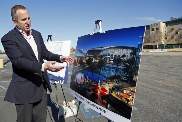 Chris Meany, senior vice president of Hollywood Park Land Company unveils an architectural rendering of a proposed NFL stadium at Hollywood Park in Inglewood, Calif., Monday, Jan. 5, 2015.  The owner of the St. Louis Rams plans to build an NFL stadium in Los Angeles County, boosting the chances that pro football could return to the region, according to the Los Angeles Times. Stan Kroenke has partnered with Stockbridge Capital Group, owners of the 238-acre Hollywood Park site in Inglewood, the newspaper reported Monday. (AP Photo/Nick Ut)