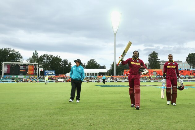 CANBERRA, AUSTRALIA - FEBRUARY 24:  Chris Gayle of West Indies acknowledges the crowd as he leaves the field after scoring 215 with his batting partner Marlon Samuels of West Indies who scored 133 not out in their partnership of 372 during the 2015 ICC Cricket World Cup match between the West Indies and Zimbabwe at Manuka Oval on February 24, 2015 in Canberra, Australia.  (Photo by Mark Kolbe/Getty Images)