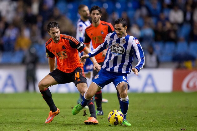 LA CORUNA, SPAIN - NOVEMBER 22:  Alberto De la Bella (R) Real Sociedad de Futbol competes for the ball with Jose Rodriguez (L) of RC Deportivo La Coruna during the La Liga match between RC Deportivo La Coruna and Real Sociedad de Futbol at Riazor Stadium on November 22, 2014 in La Coruna, Spain.  (Photo by Gonzalo Arroyo Moreno/Getty Images)